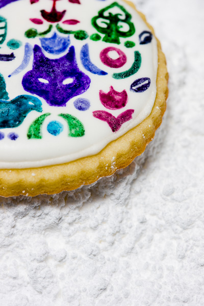 Close-up image of a hand decorated cookie on powdered sugar. © 2014 Dana Hursey Photography